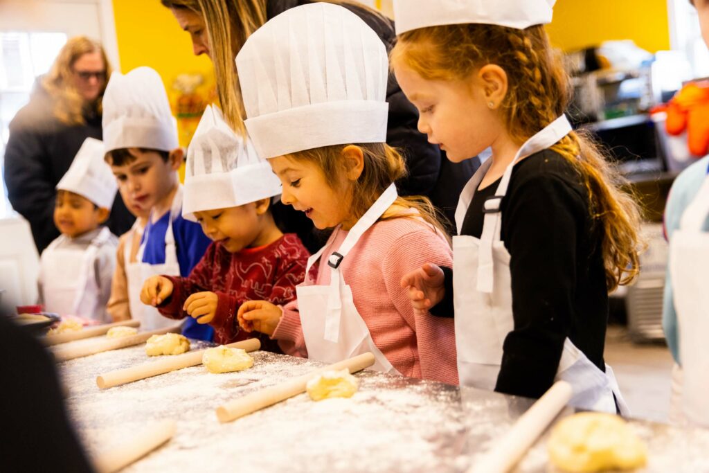 Kids in chef hats making pastries.